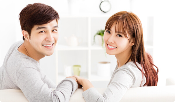Asian couple smiling and holding hands